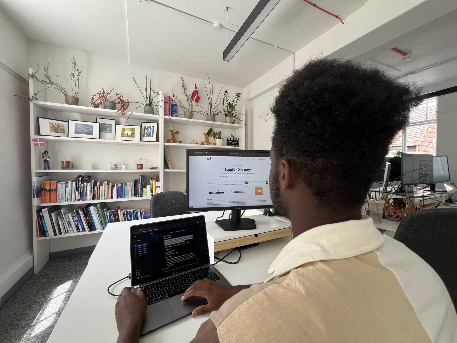 The open workspace — a member working amid plants and natural light at Dane John Gardens
